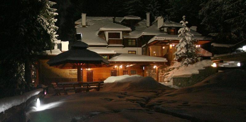 a house covered in snow at night with lights at Vila Jelena Zlatar Nova varoš in Brdo