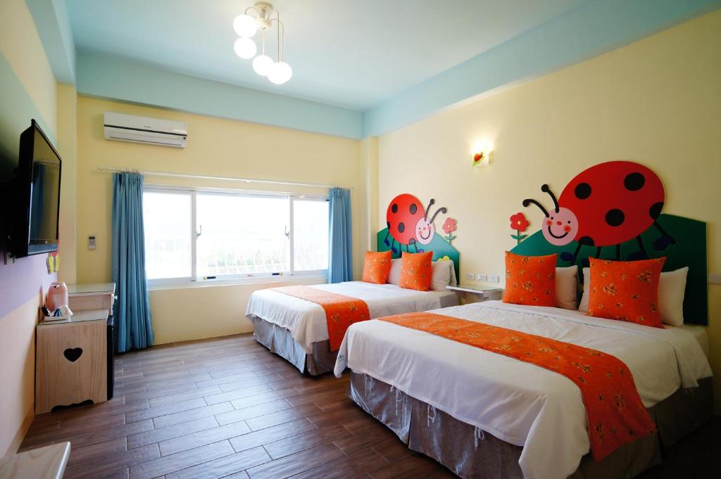 a bedroom with two beds with ladybugs painted on the walls at Kenting Avignon in Hengchun South Gate