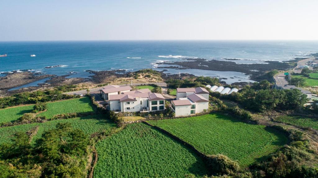 an aerial view of a house on a hill next to the ocean at Ocean Square Resort in Seogwipo