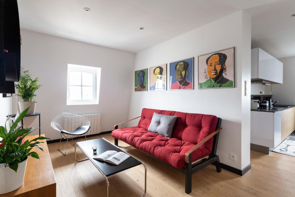 sala de estar con sofá rojo y mesa en Din'Art by Cocoonr, en Dinard