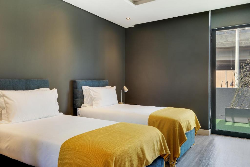 two beds sitting next to each other in a room at Urban luxury in the East Precinct in Cape Town