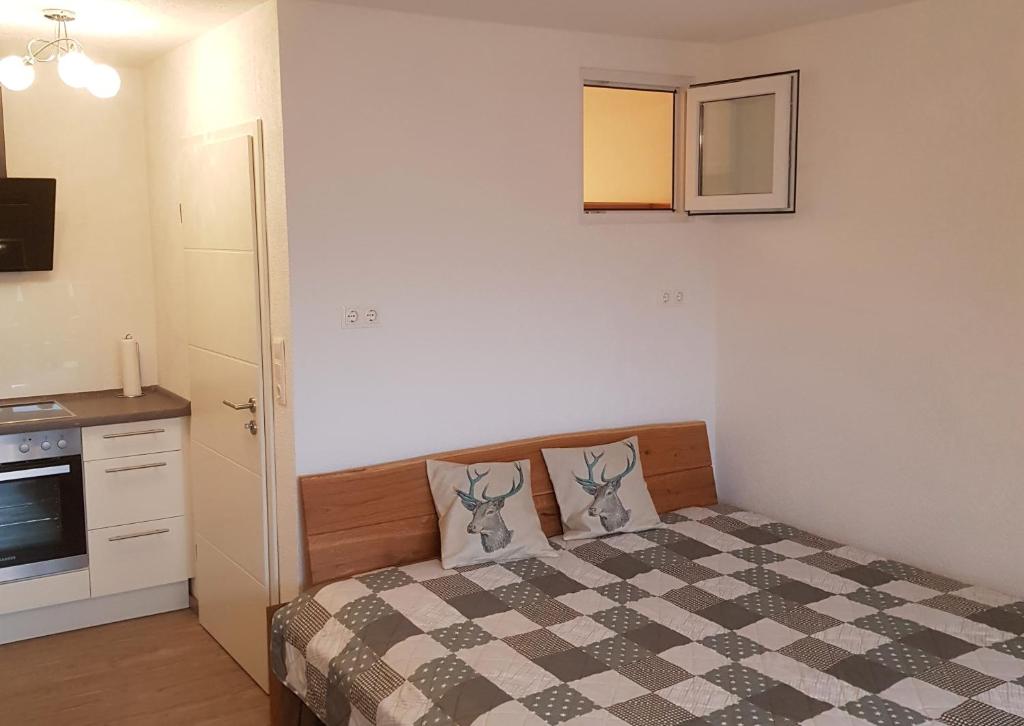 Dormitorio pequeño con cama con manta a cuadros en Berghof Appartement Top 22, en Ellmau