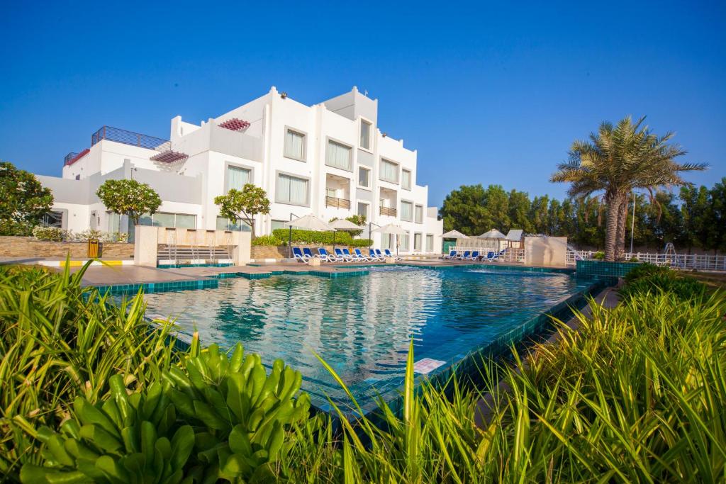a large swimming pool in front of a building at Pearl Hotel & Spa in Umm Al Quwain