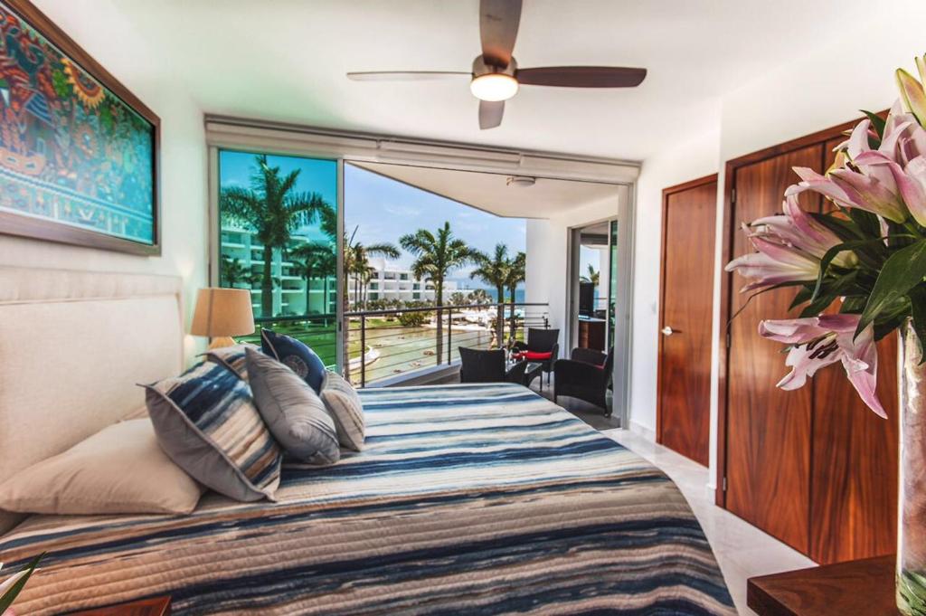 a bedroom with a bed with a view of the ocean at Departamento Aria Ocean in Nuevo Vallarta