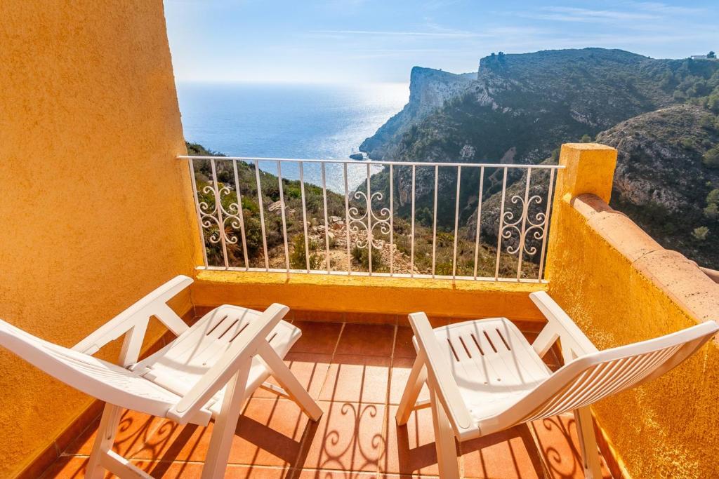 two chairs on a balcony with a view of the ocean at Villas Guzman - Apartamento Murillo in Benitachell