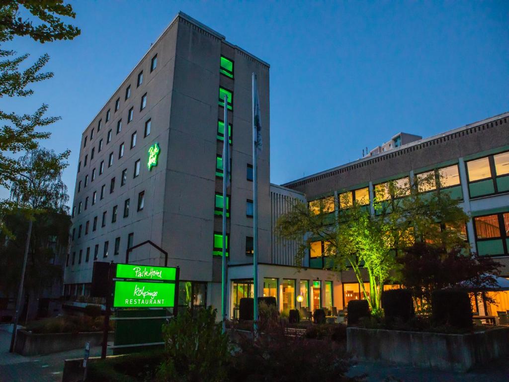 un bâtiment avec un panneau vert devant lui dans l'établissement ParkHotel Fulda, à Fulde