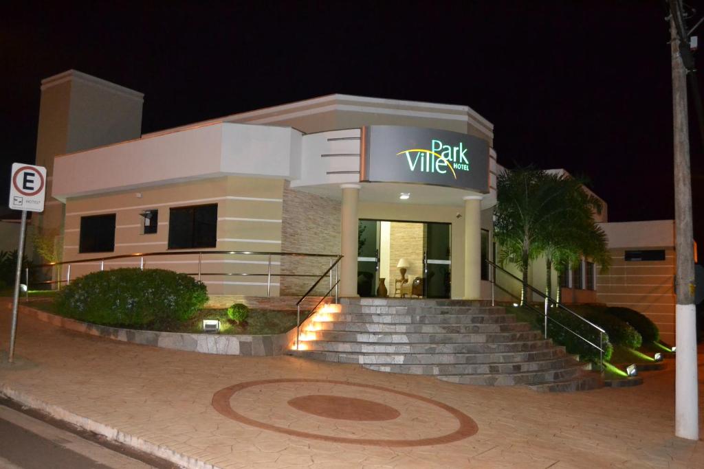een wit gebouw met een bord met wijn erop bij Ville Park Hotel in Ourinhos