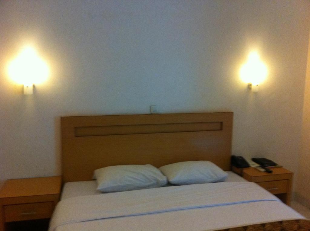 Postel nebo postele na pokoji v ubytování Syariah Arini Hotel