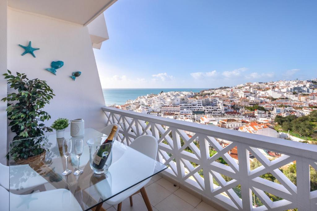 een balkon met een tafel en uitzicht op de oceaan bij Sea View Downtown - Albufeira in Albufeira