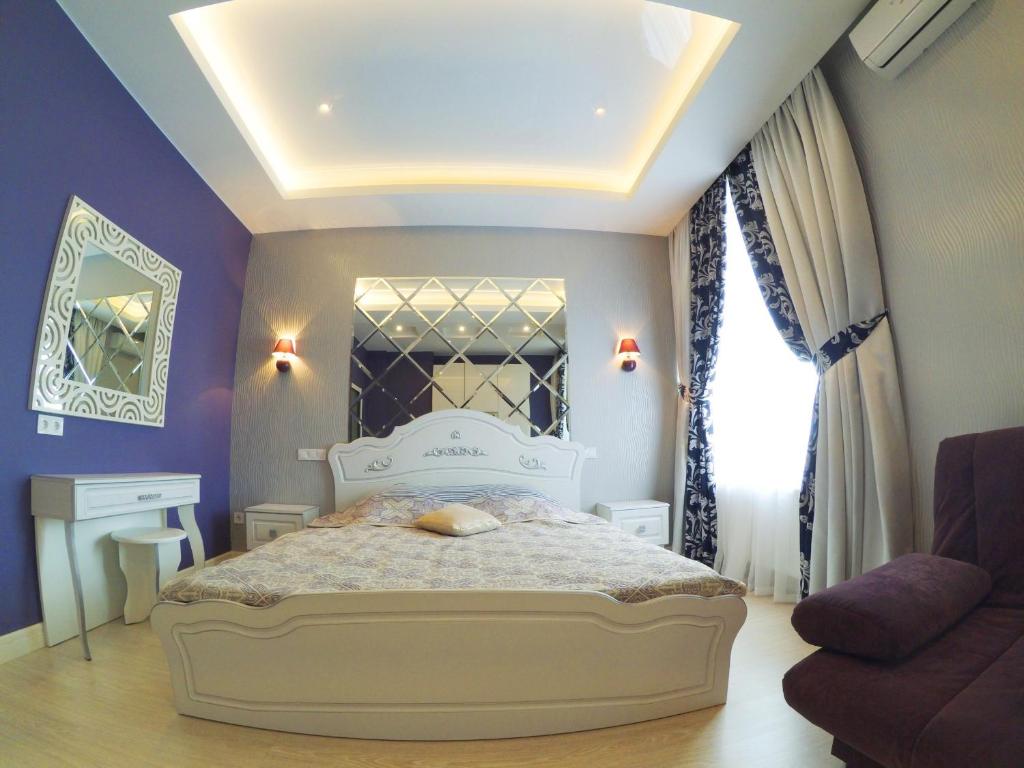 een slaapkamer met een groot wit bed en paarse muren bij Жилянская 118 ЖК Элегант 2 комнатная in Kiev