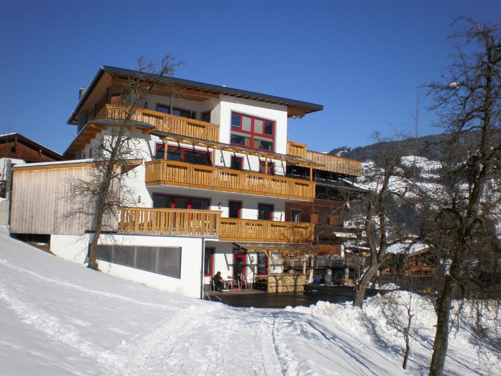 ein Gebäude auf einem schneebedeckten Hang in der Unterkunft Ferienwohnungen Neuhaushof in Hippach