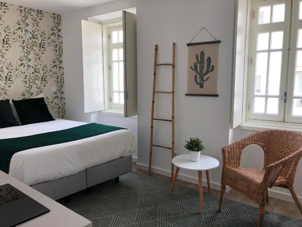 a bedroom with a bed and a chair and a ladder at São Bento na Alta St Benedict Uptown in Coimbra
