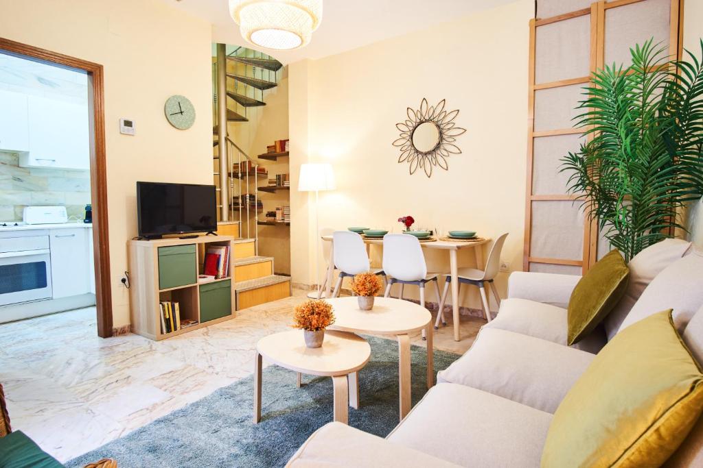 ein Wohnzimmer mit einem Sofa und einem Tisch in der Unterkunft Escoberos Courtyard Duplex by Valcambre in Sevilla