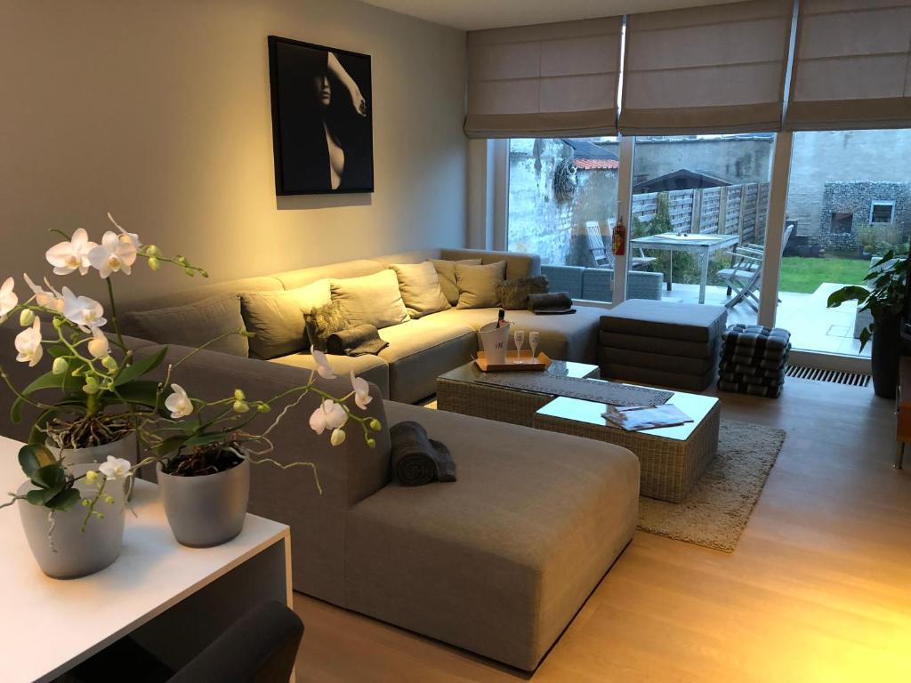 een woonkamer met een bank en een tafel bij Home Bruges Cosy Comfort Modern Couple Privacy walking distance City center Kitchen Terrace Garden in Brugge