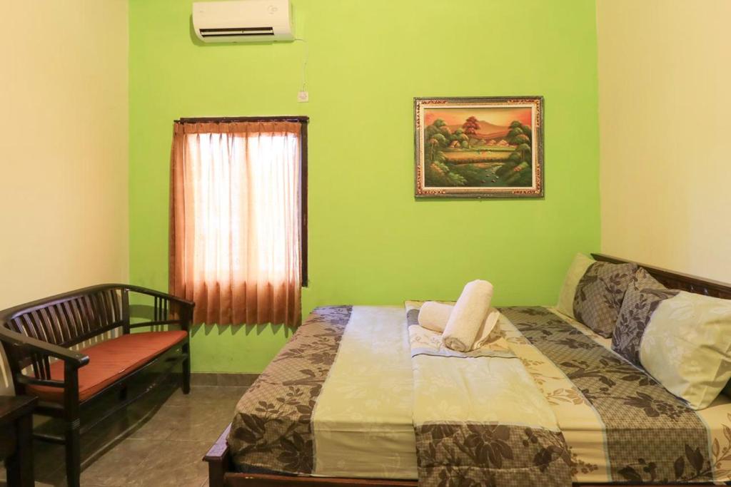 1 dormitorio con 1 cama, 1 silla y 1 ventana en Kubu Turah Homestay en Jimbaran
