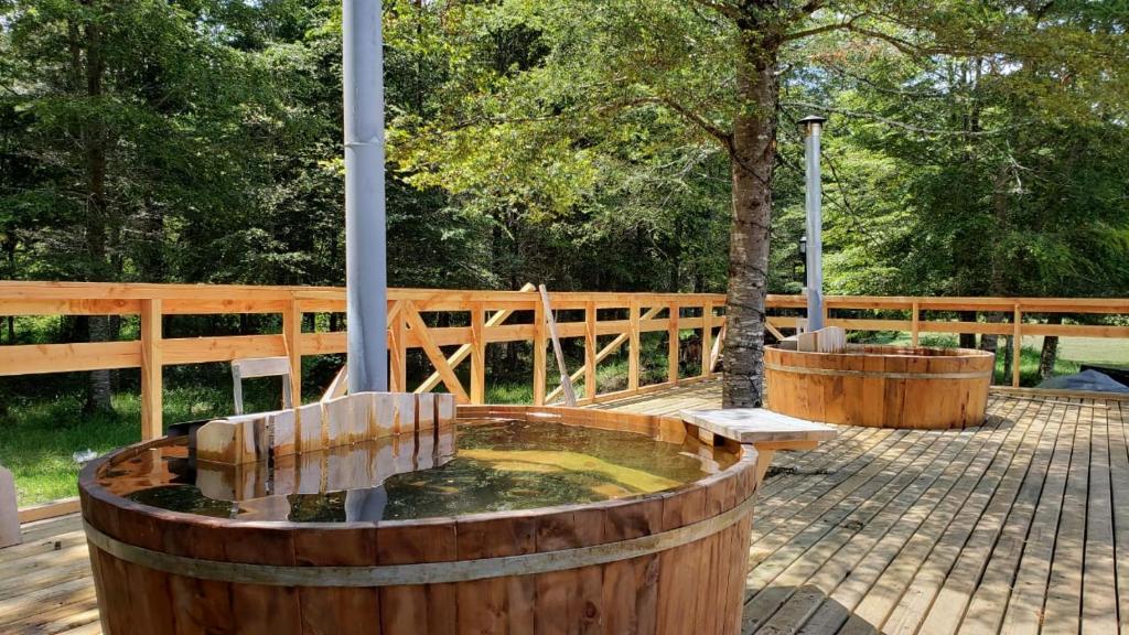 a water fountain in a wooden barrel with two benches at Cabañas Pewma Nentum in Villarrica