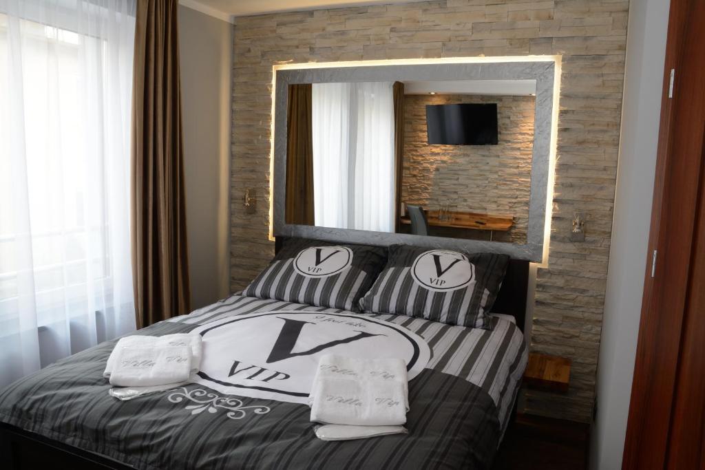 een slaapkamer met een bed met kussens en een spiegel bij Villa Vip in Gniezno