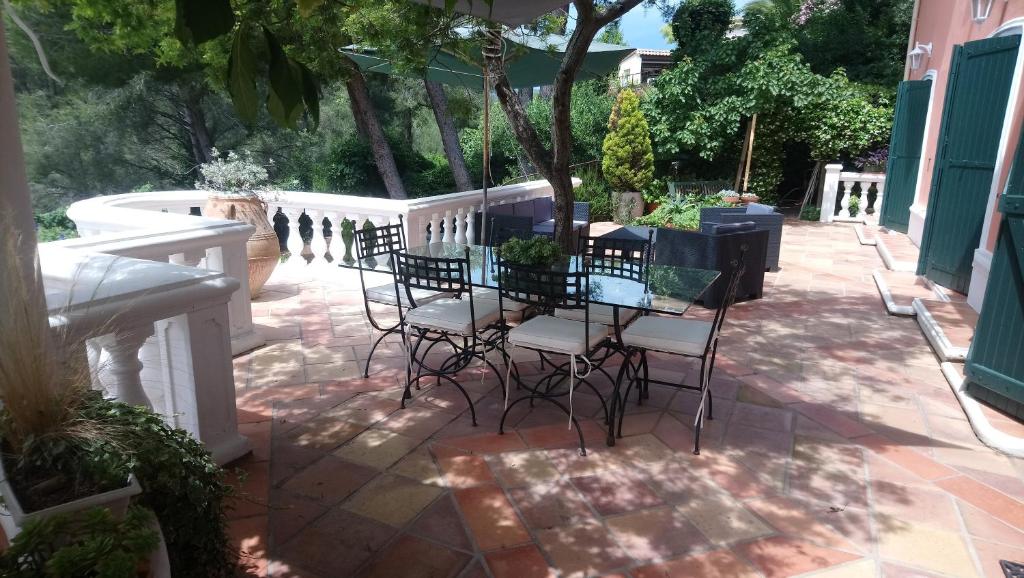 a patio with a table and chairs on a patio at La Florentine in Bandol