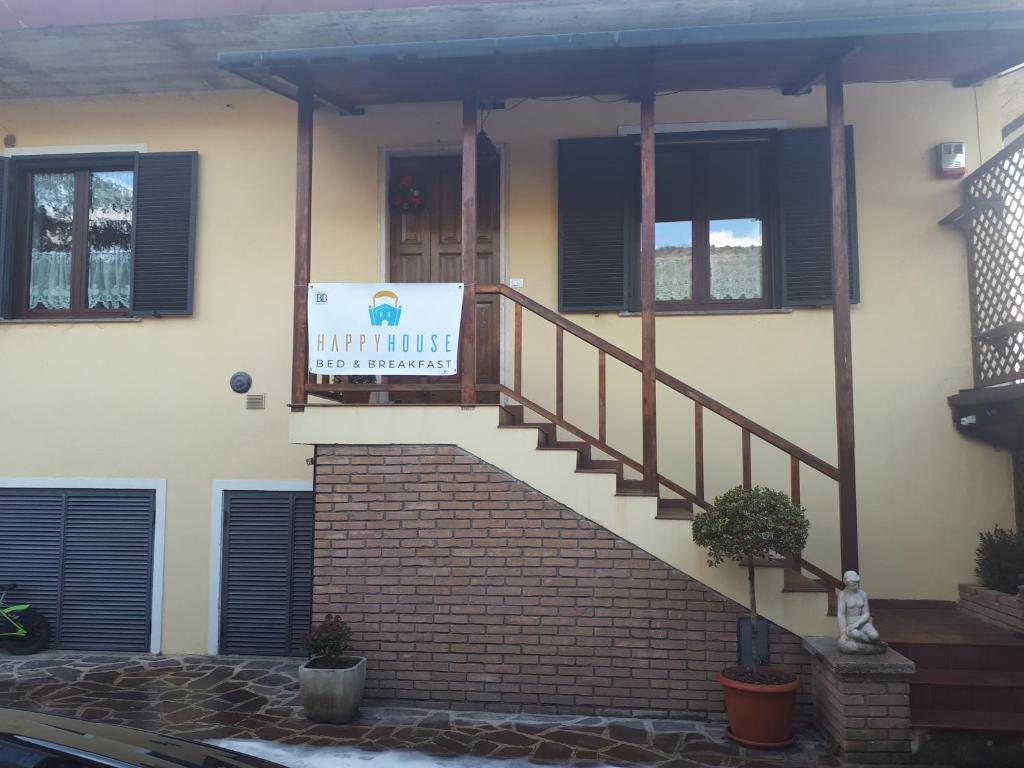 Una casa con una escalera con un cartel. en Happy House en Coppito