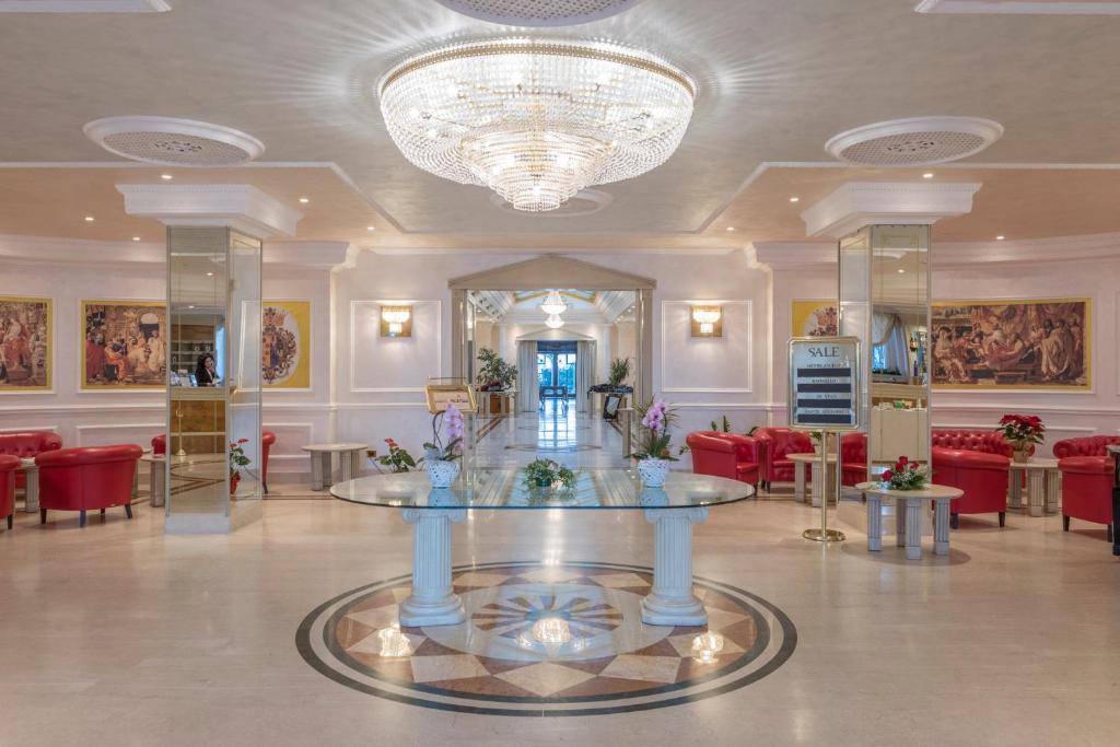 a lobby with a table and chairs and a chandelier at Hotel Villa Medici in Rocca San Giovanni