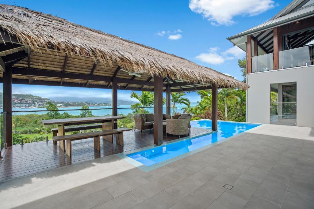 a pavilion with a picnic table and a bench at Mandalay Luxury Retreat in Airlie Beach
