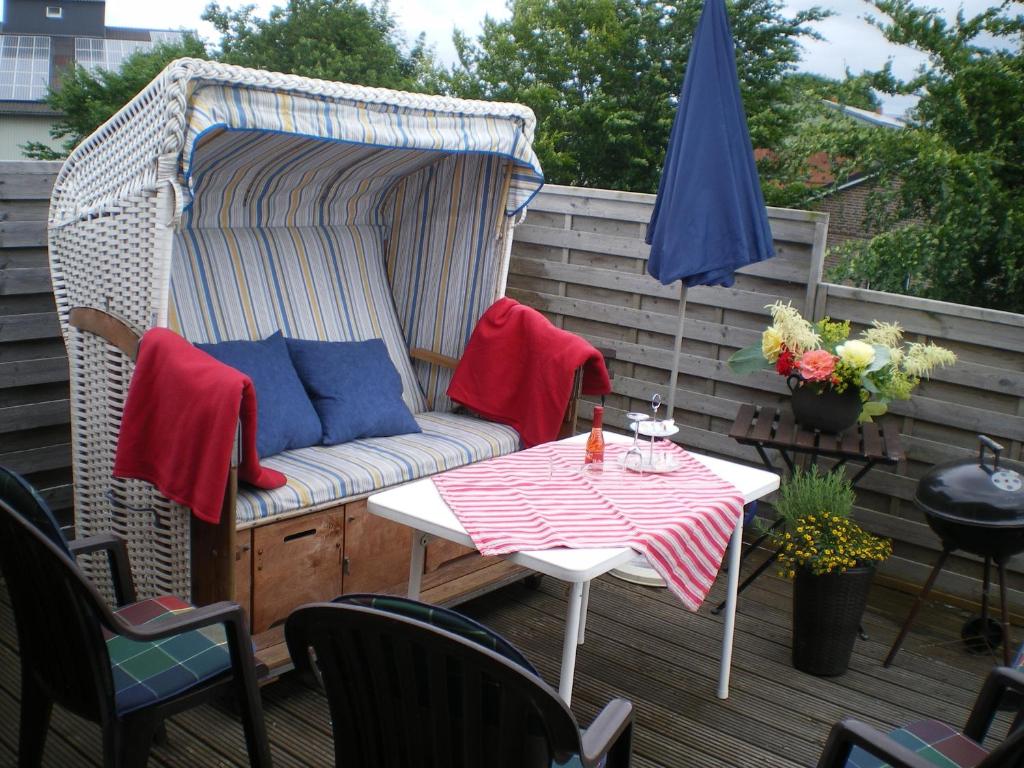 a patio with a couch and a table and an umbrella at Urlaub zwischen Nord- und Ostsee in Leck
