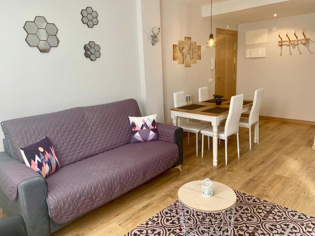 ベナスケにあるApartamentos Maladetaの紫色のソファとテーブル付きのリビングルーム