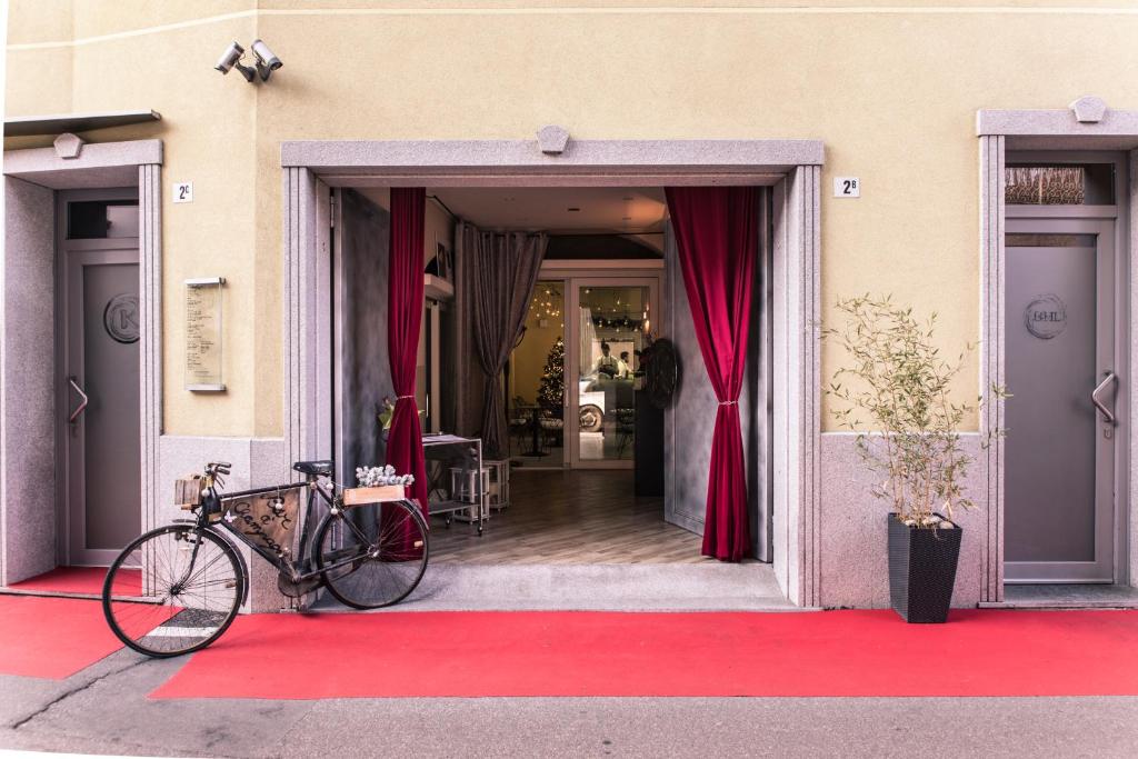 ein Fahrrad, das auf einem roten Teppich vor einem Gebäude geparkt ist in der Unterkunft BHL Boutique Rooms Legnano in Legnano