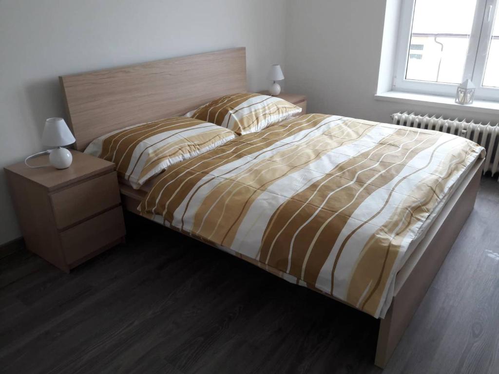 Apartman Dominik في Vysoke Tatry - Horny Smokovec: غرفة نوم بسرير كبير مع اللوح الخشبي
