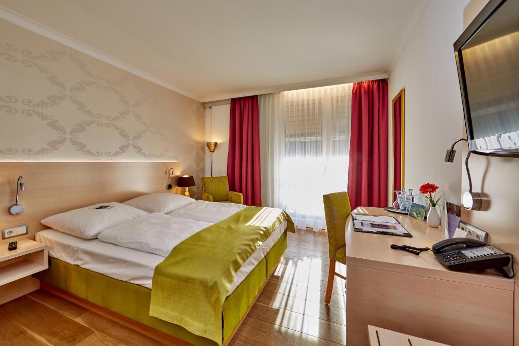 Postel nebo postele na pokoji v ubytování Hotel am Badersee