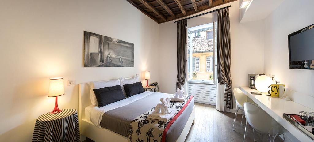 una camera con letto, scrivania e finestra di Relais Fori Imperiali a Roma
