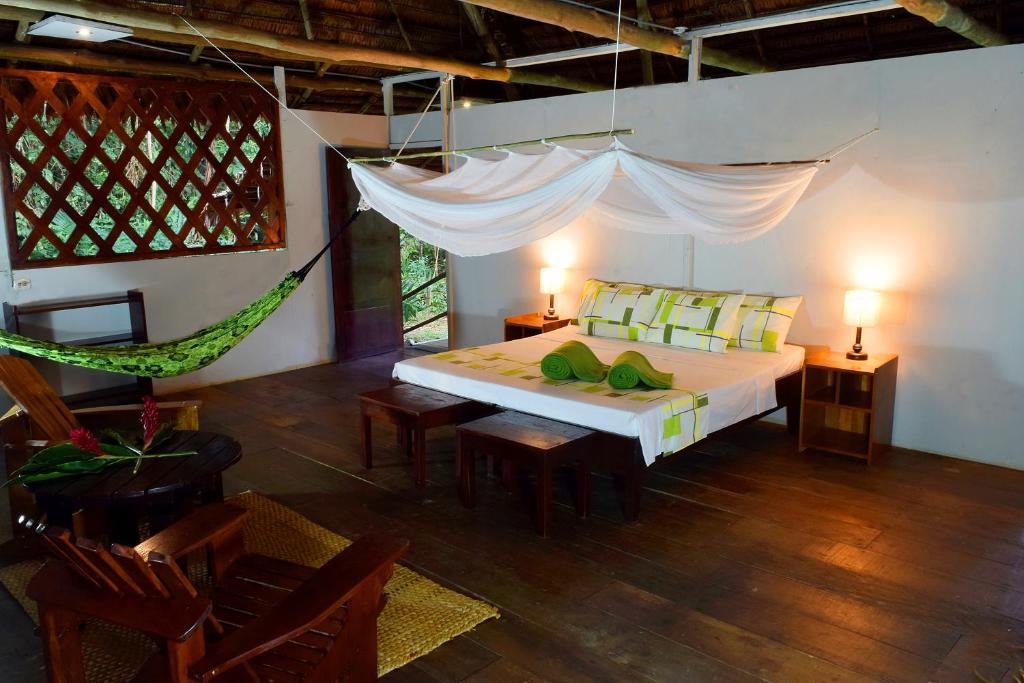 ein Schlafzimmer mit einem Bett und einer Hängematte. in der Unterkunft Explorama Lodge in Francisco de Orellana