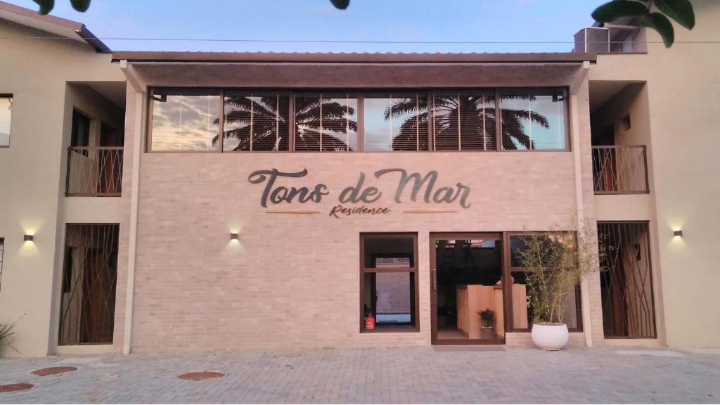 a brick building with a sign that reads tons de man at Tons de Mar Residence in Ubatuba