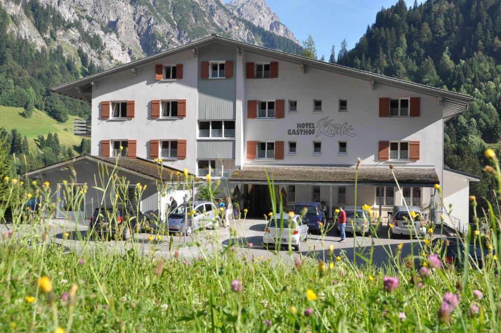 a building with cars parked in front of it at Hotel Gasthof KREUZ in Sonntag