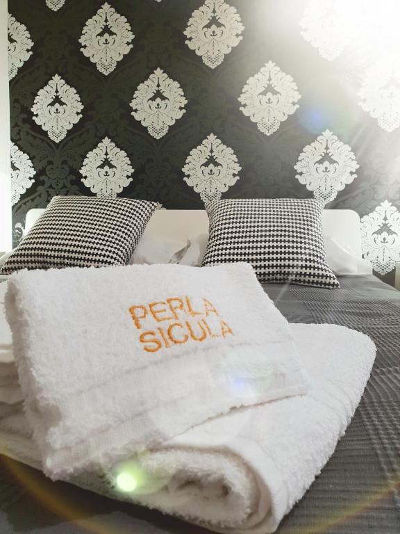 Łóżko lub łóżka w pokoju w obiekcie Perla Sicula