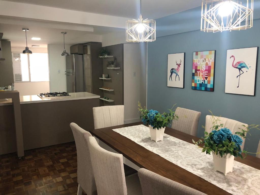 uma cozinha e sala de jantar com mesa e cadeiras em Prédio frente mar 3 quartos Balneário camboriú BrisaMarBC3 no Balneário Camboriú