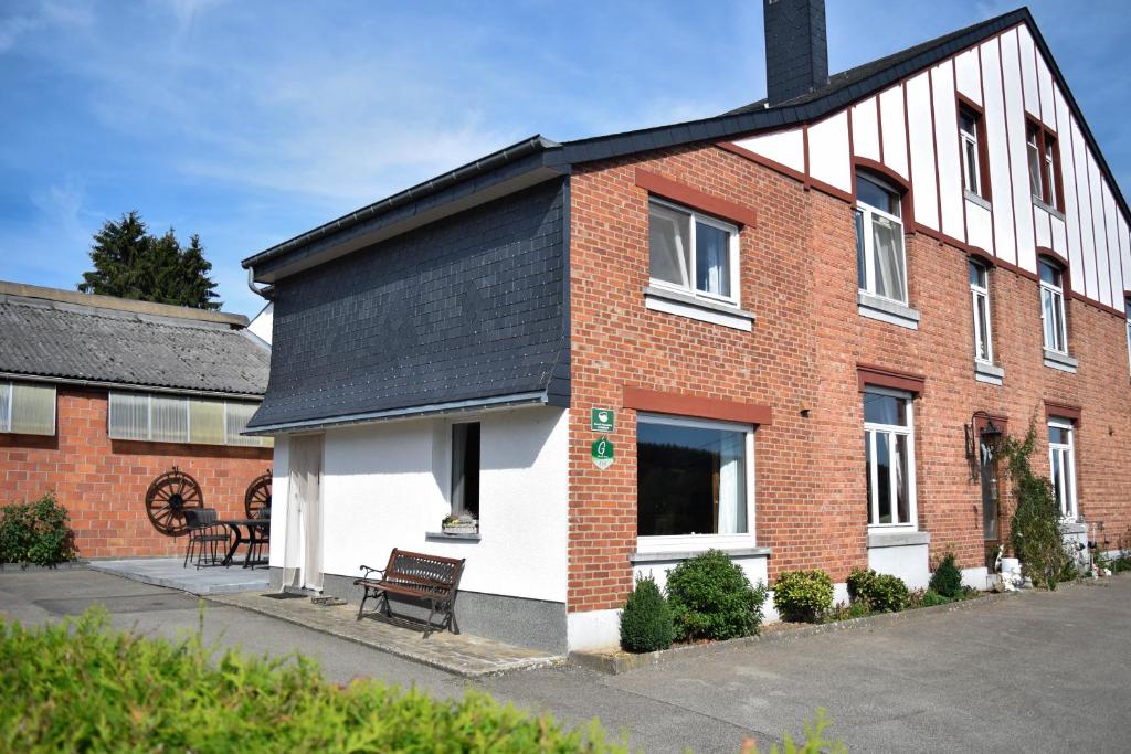 uma casa de tijolos vermelhos com um telhado preto em Le Régina em Stavelot