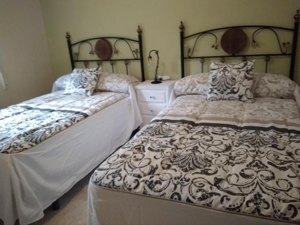 トルヒーリョにあるApartamento Turistico La Victoriaのベッドルーム1室(ベッド2台、ドレッサー付)