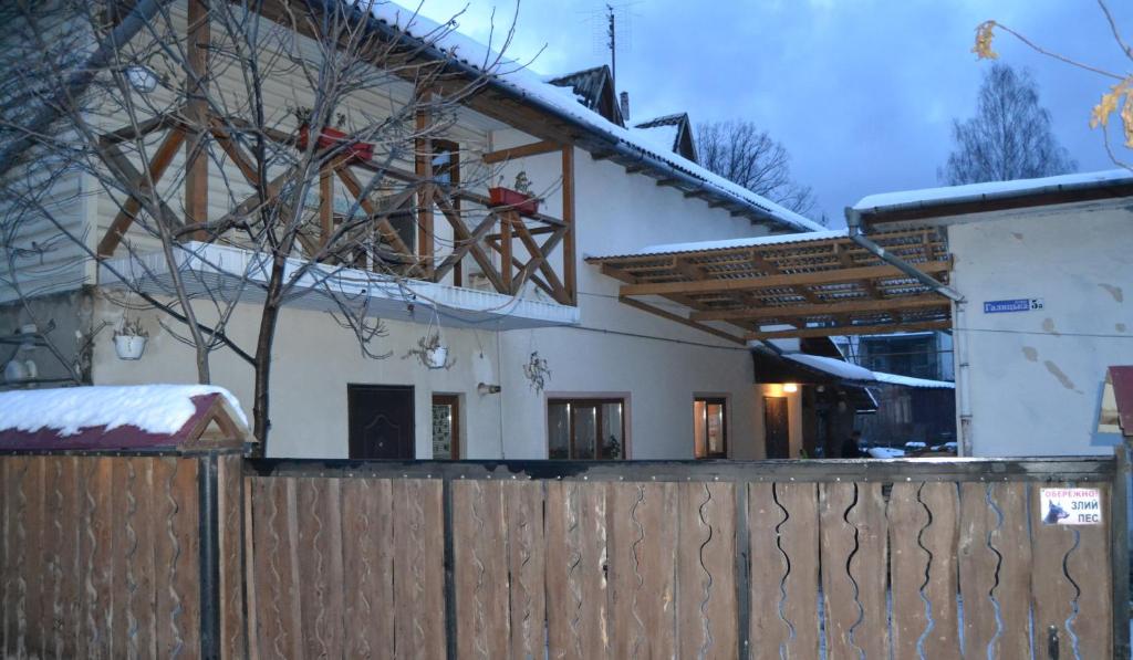 ein Haus mit einem Zaun davor in der Unterkunft Карпатський Дуб in Jaremtsche