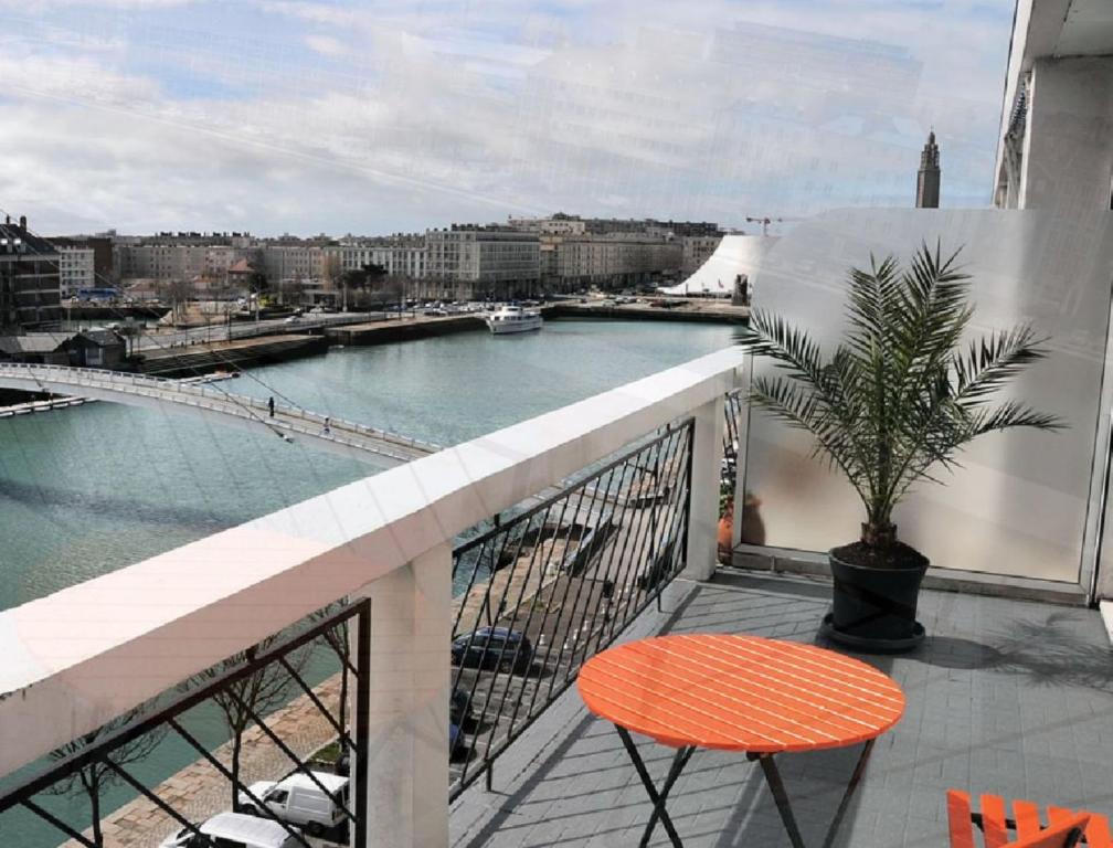 a balcony with a table and a view of a river at Escale Quai George V in Le Havre