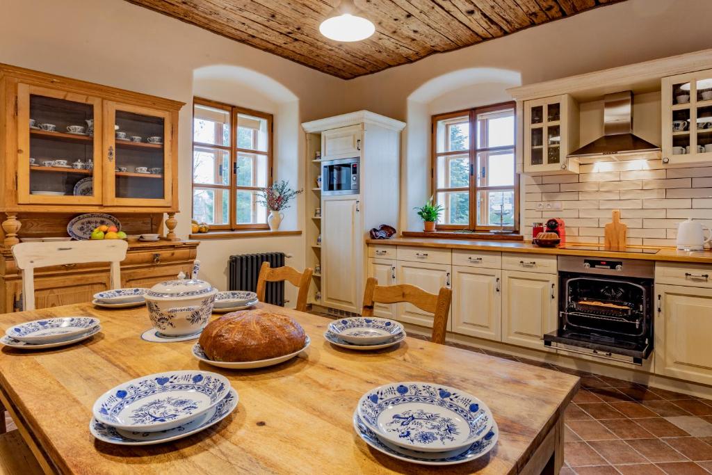 una cocina con una mesa de madera con platos azules y blancos. en Statek U Medvěda en Nová Pec