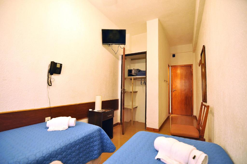 a hotel room with two beds and a television at Hotel Maracas in Villa Gesell