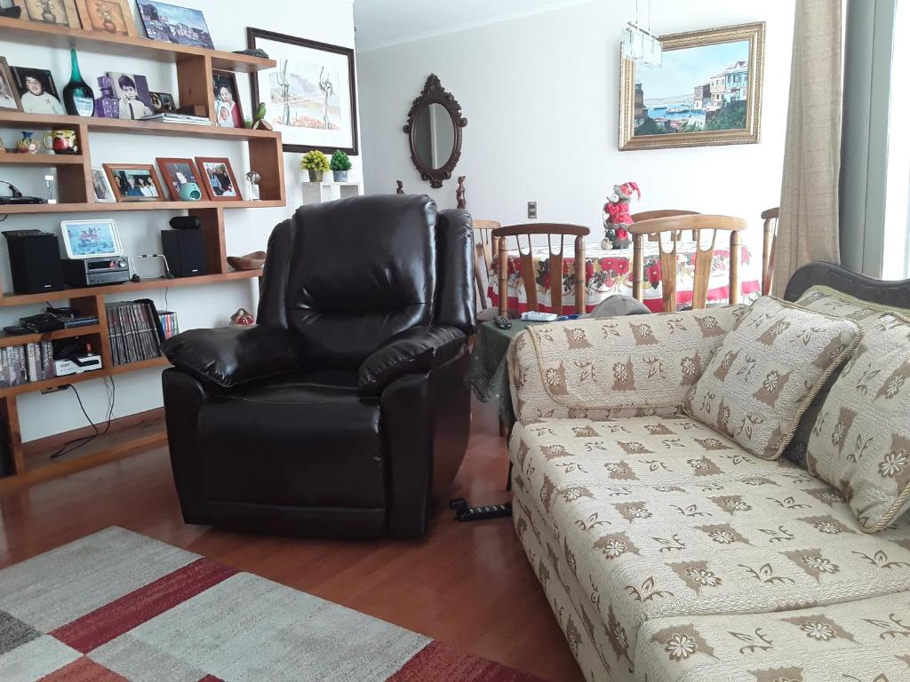 een woonkamer met een leren stoel en een bank bij Departamento Centro de Viña in Viña del Mar