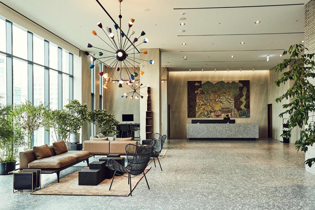 een lobby met een bank en een vleugel bij La Casa hotel Gwangmyeong in Gwangmyeong