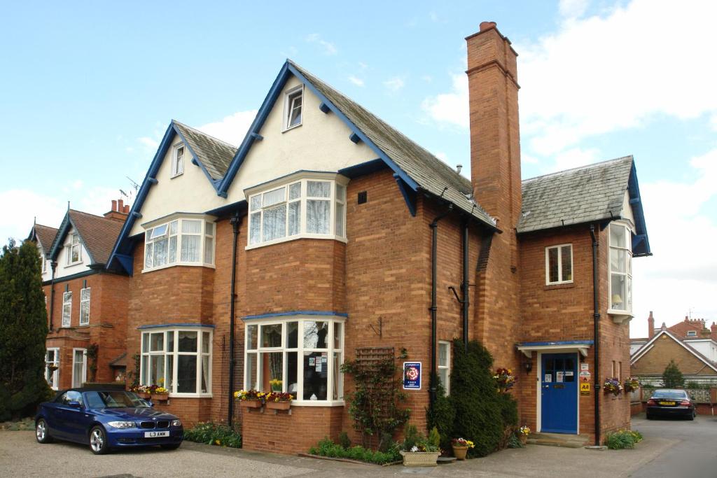 una gran casa de ladrillo con puerta azul en Midway Guest House, en York