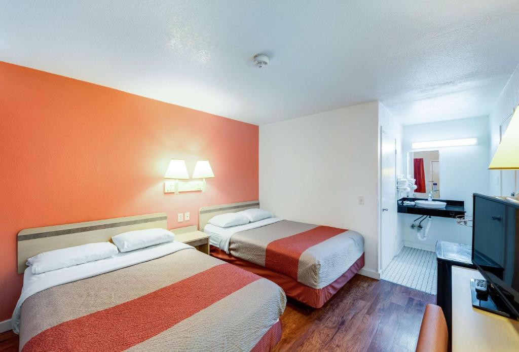 Habitación de hotel con 2 camas y TV de pantalla plana. en Motel 6-Greenville, TX en Greenville