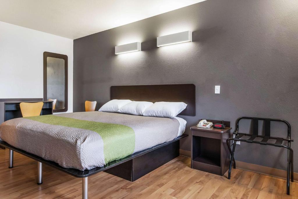sypialnia z łóżkiem z zielonym i białym kocem w obiekcie Motel 6-Alexandria, LA - South w mieście Alexandria