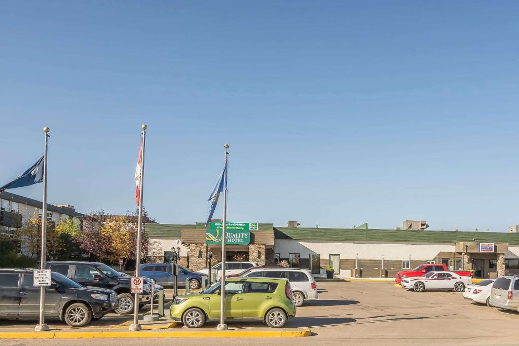 ein Parkplatz mit Autos vor einem Gebäude in der Unterkunft Quality Hotel & Conference Centre in Fort McMurray