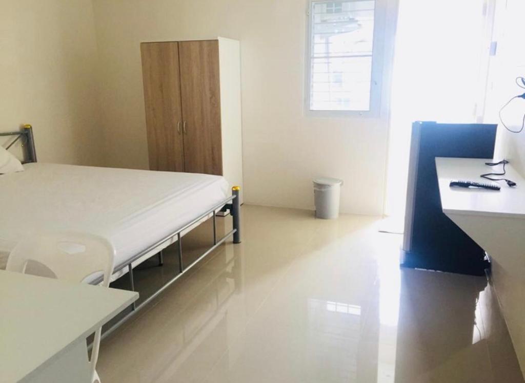 Habitación hospitalaria con cama y escritorio en SKF Apartment en Sakon Nakhon