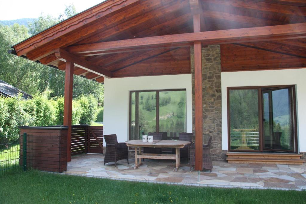 einen Pavillon mit einem Tisch und Stühlen auf einer Terrasse in der Unterkunft Haus Gartlblick in Großkirchheim